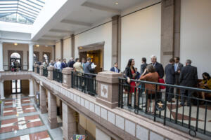 Busy hallway as witnesses, members of the public, and lobbyists crowd outside a committee hearing room in the Texas Capitol Extension.