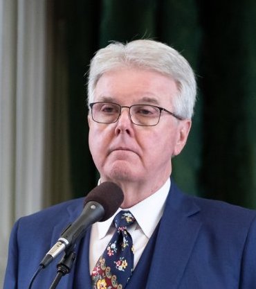 Lieutenant Governor Dan Patrick standing at a microphone in the senate chamber of Texas.