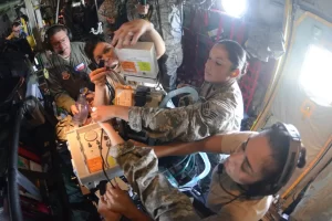 Female National Guard soldiers on board aircraft doing medical training.