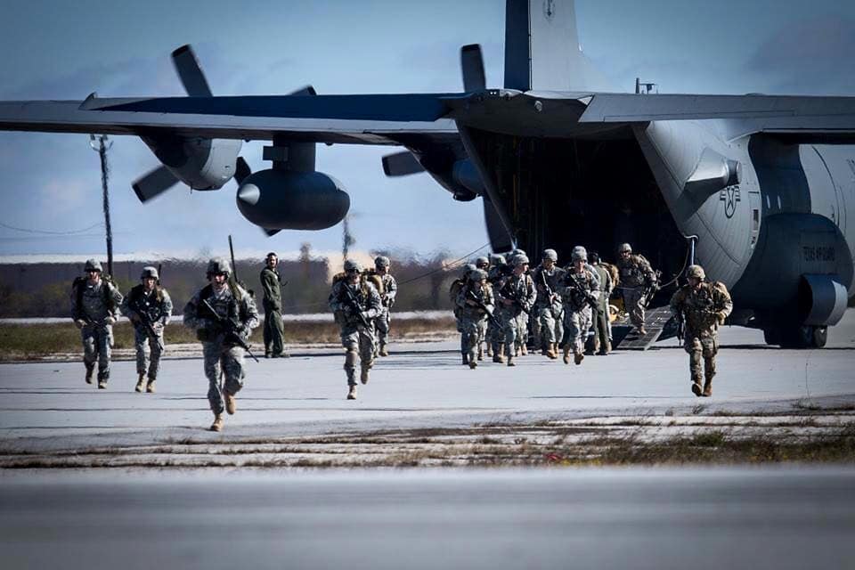 Soldiers disembarking from rear of cargo plane.