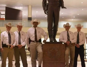 Group of five Texas Rangers wearing ties, stetson hats, and white shirts.