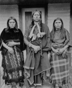 Quanah Parker, war chief of the Comanche during the Red River War (1874–75), photographed in 1890 with his wives Topay and Chonie.